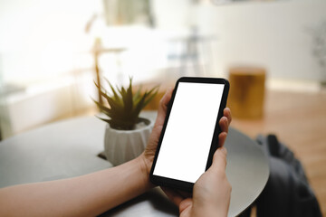 Close up of man using blank cell phone order products for shopping online within the cafe.