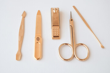 Tools of a manicure set on a white background. Gold color tools