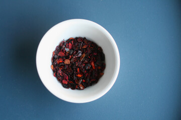 White container with spices on a blue background. Top view