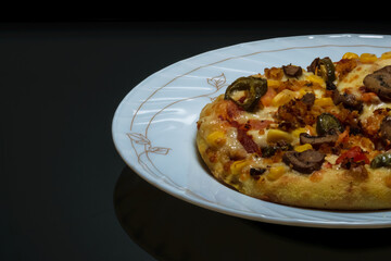 Vegetable pizza placed on a white plate and kept on a black table with space for text in the left