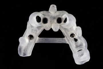 dental template basis for complex implantation of the jaw of the patient, top view on a black...