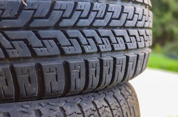 Damaged and worn old black tires on a stack. Damaged and worn old black tires on a stack. Tire...