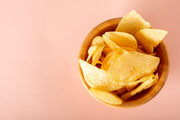 potato chips in a bowl on pink background