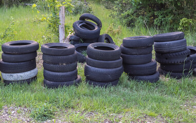 Damaged and worn old black tires on a stack. Damaged and worn old black tires on a stack. Tire...
