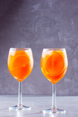 Aperol spritz cocktail on gray background. Two glasses of aperol spritz with orange slised. Summer cocktail in glass. Copy space