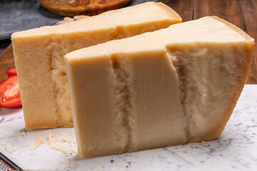 Big wedges of parmigiano-reggiano parmesan hard Italian cheese made from cow milk or Grana Padano