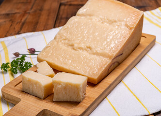 Big wedge of parmigiano-reggiano parmesan hard Italian cheese made from cow milk or Grana Padano