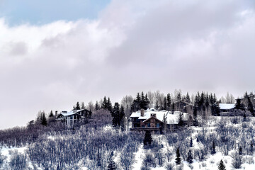 Snowy mountain top with houses that sit amid trees and evergreens in Park City