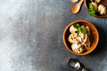 Fototapeta premium Coffee or chocolate ice cream scoop in wooden plate with mint leaf on dark background