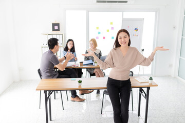 smart asian female officer sitting on table, she prepare conference and brainstorm with her team, she show cheer emotion sign and smile, happiness organization