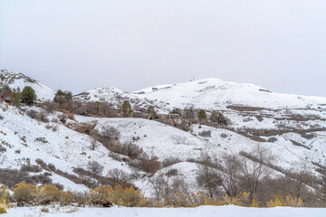 Fototapeta na wymiar Mountain homes in Salt Lake City landscape blanketed with snow in winter