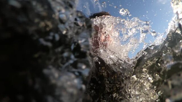 A young man films himself with an action camera as he takes a deep breath and dives into the cold Norwegian water during a hot summer day.