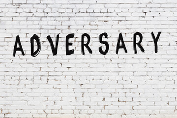 Word adversary painted on white brick wall