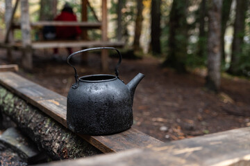 Kettle with a mug in a tourist camp. outdoor recreation in the forest.