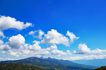 夏の青空に浮かぶ白い雲、深緑に覆われた南八ヶ岳。北横岳より。The blue sky & white clouds & Yatsugatake mountain range covers in dark green.