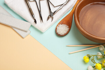 Manicure tools on blue and beige pastel paper.