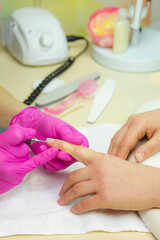 Beautician making hardware manicure. woman hands receiving nail procedure in beauty salon.