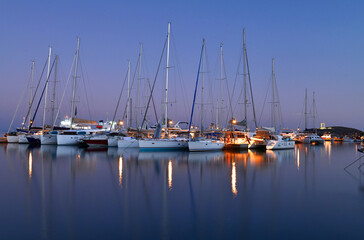 A group of yachts on a pier in the port in the early morning.