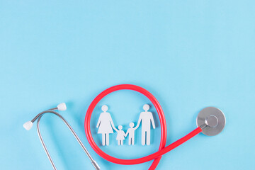 Family figure wrapped with stethoscope on light blue background. Insurance concept or Covid-19...