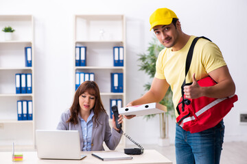 Young male courier delivering pizza to the office