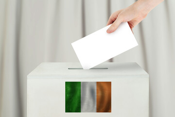 Ireland Vote concept. Voter hand holding ballot paper for election vote on polling station