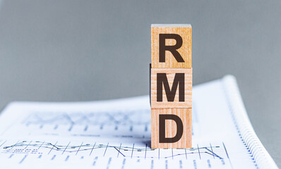 Wooden block with words RMD - acronim RMD - Required Minimum Distributions. Concept image of...