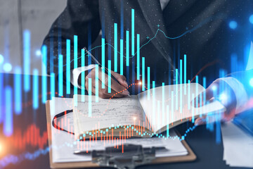 Financial stock market graph hologram and a woman taking notes. Business education and analysis concept. Multiexposure.