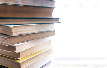 A stack of old books lying on a windowsill