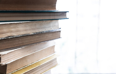 A stack of old books lying on a windowsill