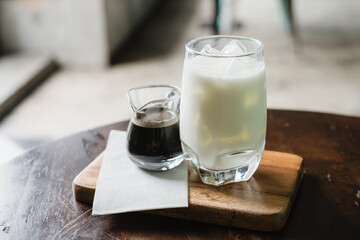 Coffee and milk in a glass, add ice, prepare to pour together to mix.