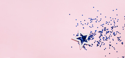Naklejka na ściany i meble Decorative white star mit blue confetti on pink background. Concept for festive background or for project.