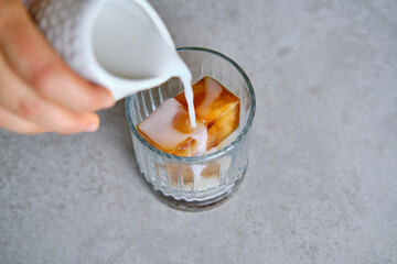 Ice cubes made with coffee in glass, preparing refreshing coffee drink