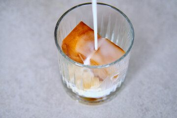 Ice cubes made with coffee in glass, preparing refreshing coffee drink