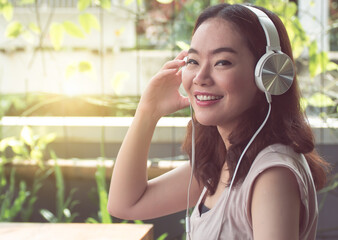 Asian woman is listening to music at home