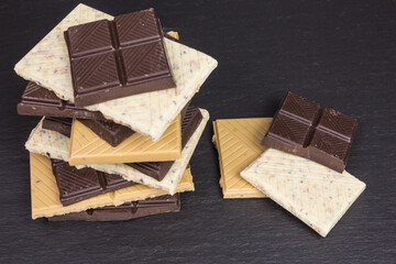 pile of pieces of dark and white chocolate with coffee, cookie and pecan nut pieces