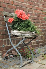 Fototapeta na wymiar Stuhl mit Strohkranz und Blumen