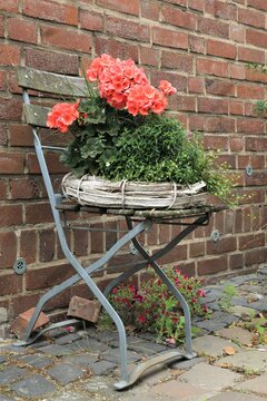 Stuhl mit Strohkranz und Blumen