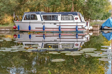 Fototapeta na wymiar 23 Small pleasure boat moored in the private staithe at Barton Turf in the Norfolk Broads