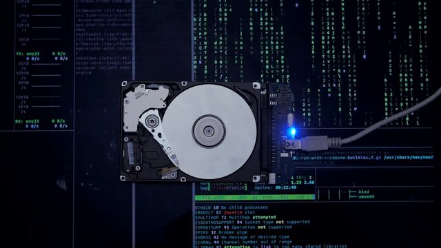 Work of hacked hard drive inside. Hacker breaks sensitive data from a hard drive. Against the background, lines of code and data flash. Cybersecurity. Government secret data hacking technology