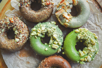 Donuts delivery on paper.Delicius sweet dessert food in flat lay on table.Tasty iced doughnuts glazed & decorated with nuts.Bakery products for lunch meal.Pastry product set for snack in pastry cafe