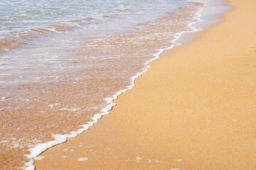 White foam on a sandy beach. Copy space.