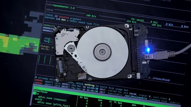Work of hacked hard drive inside. Hacker breaks sensitive data from a hard drive. Against the background, lines of code and data flash. Cybersecurity. Government secret data hacking technology