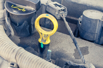 yellow oil dipstick in a car engine close-up
