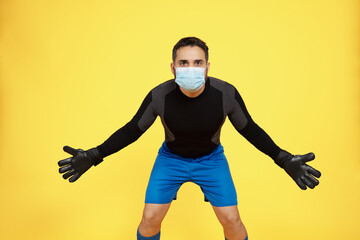 football soccer goalkeeper trying to make a stop with a mask on his face