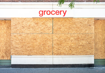 Storefront covered in plywood to prevent looters from destroying the store and steal product