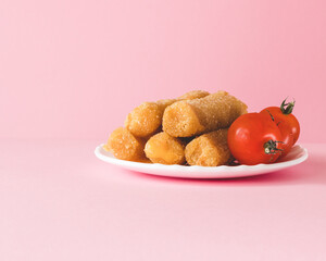 The plate with mozarella cheese sticks and tomato on pink background, Menu setup. Close-up