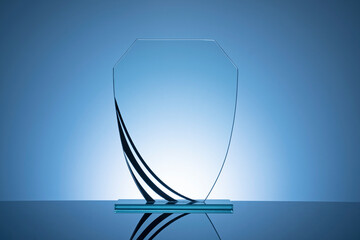 Elegant blank glass shield trophy on dark blue - obrazy, fototapety, plakaty
