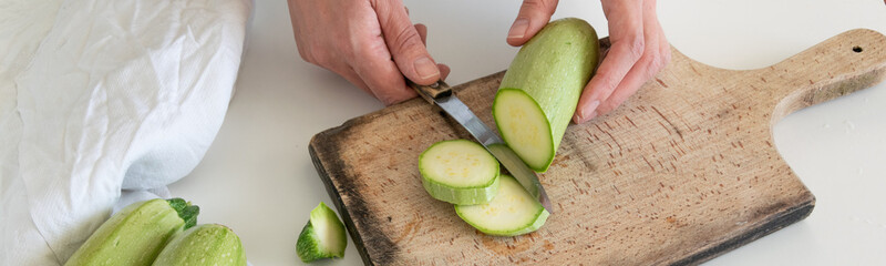 Top view of woman hands preparing fresh ripe garden zucchini. Raw organic vegetables
