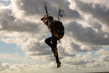 woman flying the paraglider alone in the sky