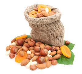 dried fruits and nuts in linen basket on green leaves isolated on white background